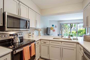 a kitchen with white cabinets and stainless steel appliances